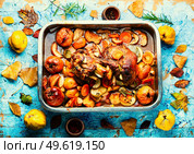 Pork knuckle stewed with quince and apples in tray. Pork shank baked with apples. Стоковое фото, агентство Ingram Publishing / Фотобанк Лори