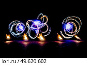 fiery pieces of a fire show against a dark sky and thunderstorms. Стоковое фото, агентство Ingram Publishing / Фотобанк Лори