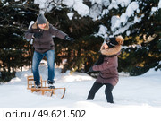 boy and girl outdoors on a winter walk playing snowballs and sledding. Стоковое фото, агентство Ingram Publishing / Фотобанк Лори
