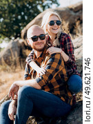 Guy and girl in caged shirts and trekking shoes on granite rocks. Стоковое фото, агентство Ingram Publishing / Фотобанк Лори