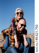 Guy and girl in caged shirts and trekking shoes on granite rocks. Стоковое фото, агентство Ingram Publishing / Фотобанк Лори