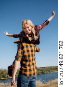 Guy and girl in caged shirts and trekking shoes on granite rocks. Стоковое фото, агентство Ingram Publishing / Фотобанк Лори