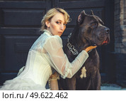 Girl in an old dress with ruffles and a big dark dog. Стоковое фото, агентство Ingram Publishing / Фотобанк Лори