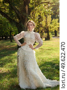 Girl model with white hair in a retro dress with ruffles in a green park. Стоковое фото, агентство Ingram Publishing / Фотобанк Лори