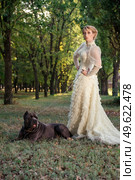 Girl in an old dress with ruffles and a big dark dog. Стоковое фото, агентство Ingram Publishing / Фотобанк Лори