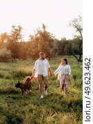 Big dog for a walk with a guy and a girl on the green prairie. Стоковое фото, агентство Ingram Publishing / Фотобанк Лори