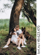 Big dog for a walk with a guy and a girl on the green prairie. Стоковое фото, агентство Ingram Publishing / Фотобанк Лори