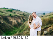 a guy with a girl in light clothes on the background of a green canyon of erosion of the earth. Стоковое фото, агентство Ingram Publishing / Фотобанк Лори