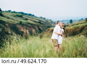 a guy with a girl in light clothes on the background of a green canyon of erosion of the earth. Стоковое фото, агентство Ingram Publishing / Фотобанк Лори