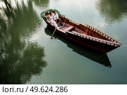 a boat trip for a guy and a girl along the canals and bays of the river overgrown with wild willows. Стоковое фото, агентство Ingram Publishing / Фотобанк Лори