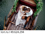 a boat trip for a guy and a girl along the canals and bays of the river overgrown with wild willows. Стоковое фото, агентство Ingram Publishing / Фотобанк Лори