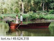 a boat trip for a guy and a girl along the canals and bays of the river overgrown with wild willows. Стоковое фото, агентство Ingram Publishing / Фотобанк Лори