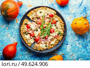 Pizza with salami, cheese, tomato on a pumpkin crust. Homemade autumn recipe. Pizza on pumpkin flatbread. Стоковое фото, агентство Ingram Publishing / Фотобанк Лори