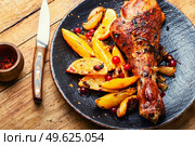 Turkey meat baked in oranges. Roasted turkey leg on rustic wooden table. Grilled turkey drumstick with citrus. Стоковое фото, агентство Ingram Publishing / Фотобанк Лори