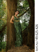 girl in a dress of green palm leaves on a forest lake. Стоковое фото, агентство Ingram Publishing / Фотобанк Лори