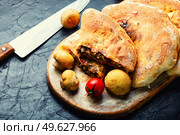 Calzone, a closed pie with vegetable filling. Dish of italian cuisine. Calzone - Italian pie, pizza. Стоковое фото, агентство Ingram Publishing / Фотобанк Лори