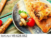 Calzone, a closed pie with vegetable filling. Dish of italian cuisine. Calzone - Italian pie, pizza. Стоковое фото, агентство Ingram Publishing / Фотобанк Лори