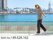 Happy young black girl balancing while strolling along the harbor of a coastal city.. Young black girl balancing while strolling along the harbor of a coastal city. Стоковое фото, агентство Ingram Publishing / Фотобанк Лори