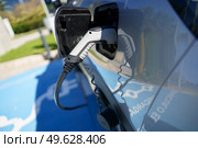 Car charging its electric battery at one charging point for electric vehicles located on the street.. Refueling an electric car, an environment friendly alternative. Стоковое фото, агентство Ingram Publishing / Фотобанк Лори