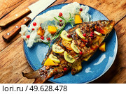 Appetizing baked carp fish with cranberries, kiwi and mango.. Baked river fish with fruits. Стоковое фото, агентство Ingram Publishing / Фотобанк Лори