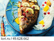 Baked fish carp with fruits, berries and spices.. Tasty crucian fried with kiwi and mango. Стоковое фото, агентство Ingram Publishing / Фотобанк Лори