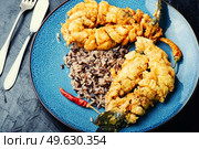 Fried sea bass fish with rice on rice paper.. Appetizing fried sea bass fish, seafood. Стоковое фото, агентство Ingram Publishing / Фотобанк Лори