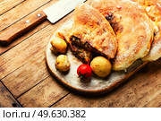 Calzone, a closed pie with vegetable filling. Dish of italian cuisine. Calzone - Italian pie, pizza. Стоковое фото, агентство Ingram Publishing / Фотобанк Лори