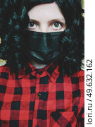 Young woman wearing a black face mask. Стоковое фото, агентство Ingram Publishing / Фотобанк Лори