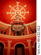 antique ceiling chandelier with lamps in red light on vaulted ceiling. Стоковое фото, агентство Ingram Publishing / Фотобанк Лори