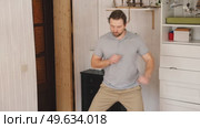 Handsome bearded man dance, have fun at home listens song, moves to music, feels overjoyed, celebrate good news, relish carefree life looks happy. Young adult male twirls, grooves. Brutal man dancer. Стоковое видео, видеограф Марина Демидюк / Фотобанк Лори