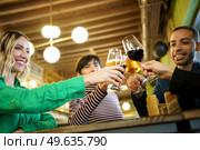 From below happy diverse male and female friend clinking glasses of alcohol during party in weekend in pub. Man and women proposing toast during party. Стоковое фото, агентство Ingram Publishing / Фотобанк Лори