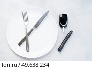 Diabetes diet planning concept, empty plate with fork, knife and glukemetr, fasting diet and dieabetes sugar level control equipment. Diabetes diet planning concept. Стоковое фото, агентство Ingram Publishing / Фотобанк Лори