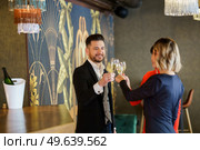 Company of cheerful friendly people in elegant outfits clicking glasses with champagne and proposing toast while celebrating event in restaurant. Group of friends clicking glasses in bar. Стоковое фото, агентство Ingram Publishing / Фотобанк Лори