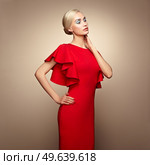 Fashion portrait of elegant woman with magnificent hair. Blonde girl. Perfect make-up. Girl in elegant red dress. Girl posing. Studio photo. Стоковое фото, агентство Ingram Publishing / Фотобанк Лори
