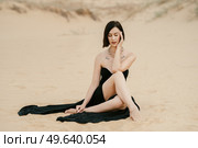 girl in a black long dress in a sandy desert under a blue sky. Стоковое фото, агентство Ingram Publishing / Фотобанк Лори