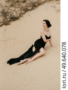 girl in a black long dress in a sandy desert under a blue sky. Стоковое фото, агентство Ingram Publishing / Фотобанк Лори