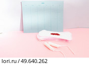 Menstrual pad with schedule card background, menstrual period and ovulation and fertility tracker, baby birth planning and natural control. Menstrual pad with schedule card background. Стоковое фото, агентство Ingram Publishing / Фотобанк Лори