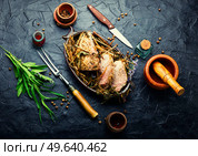 Delicious meat roasted in fresh hay. Baked pork meat in spicy herbs.Autumn food. Roast pork in hay with herbs. Стоковое фото, агентство Ingram Publishing / Фотобанк Лори