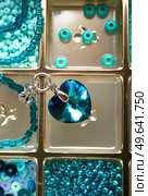 different azure beads and chrystals in box around old style wooden background. close up. Стоковое фото, агентство Ingram Publishing / Фотобанк Лори