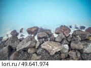 Lava rocks by the Blue Lagoon in Iceland with colourful turquois waters. Стоковое фото, агентство Ingram Publishing / Фотобанк Лори