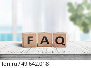FAQ answers and questions sign made of wooden blocks. Standing on a table in a bright living area. Стоковое фото, агентство Ingram Publishing / Фотобанк Лори