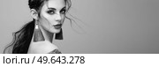 Brunette girl with perfect makeup. Beautiful model woman with curly hairstyle. Care and beauty hair products. Lady with braided hair. Model with jewelry. Black and White photo. Стоковое фото, агентство Ingram Publishing / Фотобанк Лори