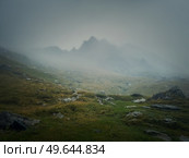 Mountain peak seen through the dense fog. Rainy scene in the mounts, hiking in the mist landscape. Стоковое фото, агентство Ingram Publishing / Фотобанк Лори