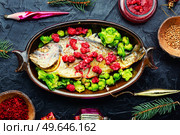 Baked whole fish dorado in fruit marinade. Christmas food. Fragrant roasted fish, top view. Стоковое фото, агентство Ingram Publishing / Фотобанк Лори