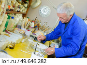 a mature male goldsmith preparing the glue paste. Стоковое фото, агентство Ingram Publishing / Фотобанк Лори