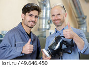workers holding mask with toxins filter giving thumbs up. Стоковое фото, агентство Ingram Publishing / Фотобанк Лори