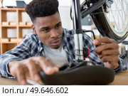 man securing bicycle seat with allen key. Стоковое фото, агентство Ingram Publishing / Фотобанк Лори