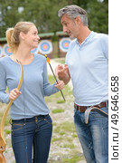 Man and woman at archery centre. Стоковое фото, агентство Ingram Publishing / Фотобанк Лори