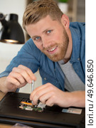 happy man using screwdriver and repairing a broken laptop. Стоковое фото, агентство Ingram Publishing / Фотобанк Лори