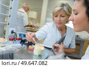 dental technician holding articulator with prosthesis. Стоковое фото, агентство Ingram Publishing / Фотобанк Лори